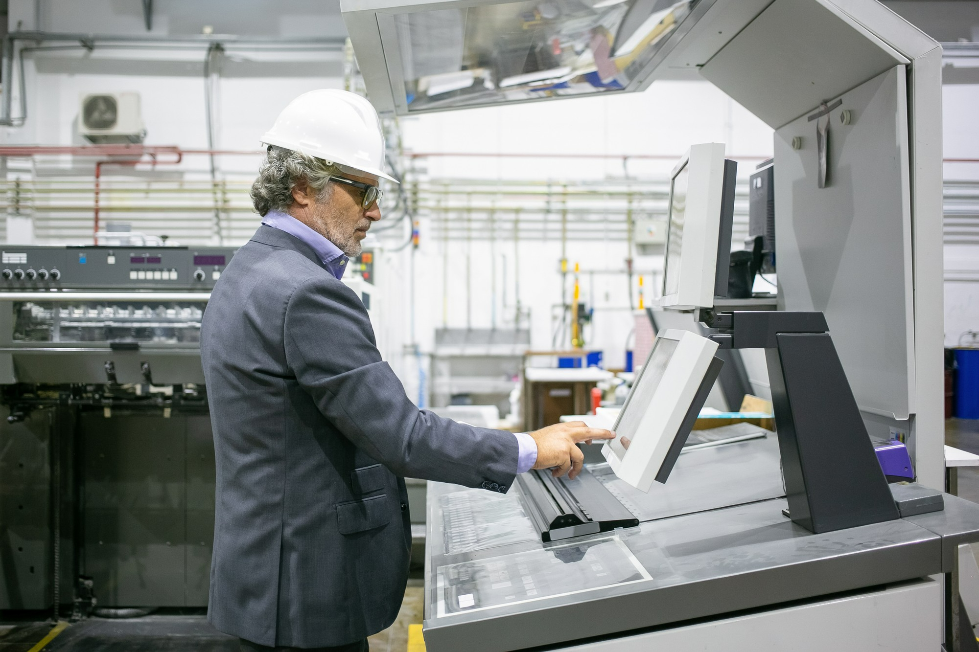 Sistema de produção industrial com operador a controlar processos em máquina com interface digital